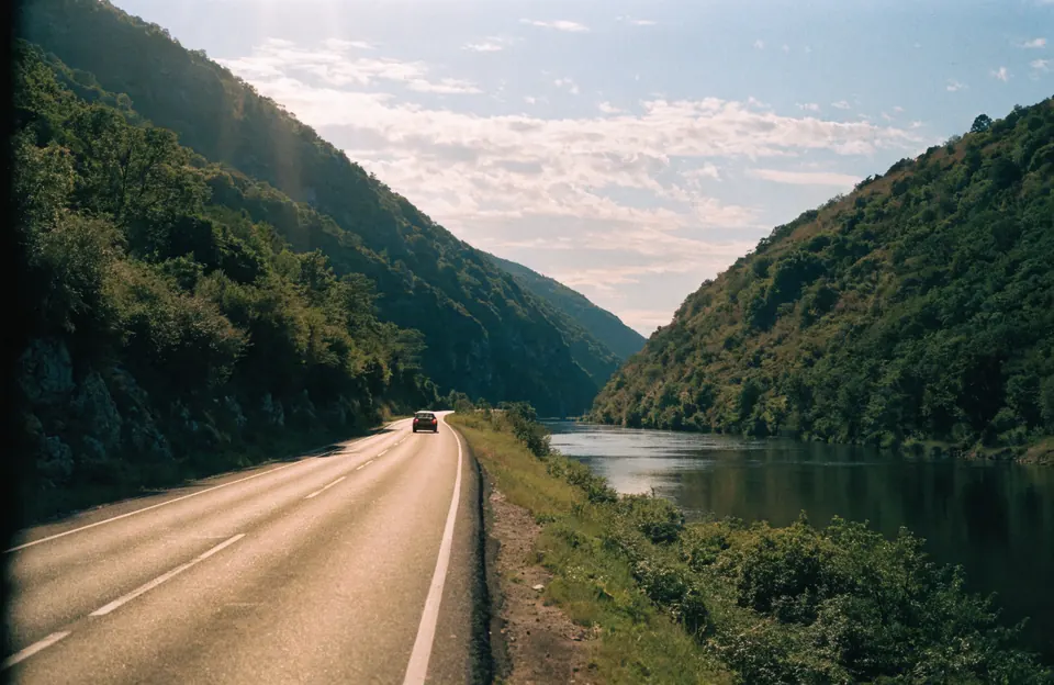 Auto na putu kroz zelenu klisuru u letnje veče