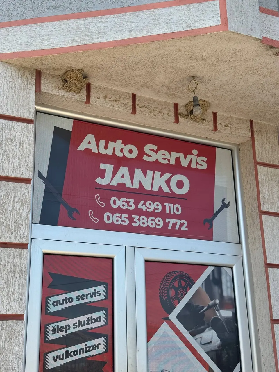 Ulaz u auto servis Janko sa tablom i brojevima telefona iznad vrata
