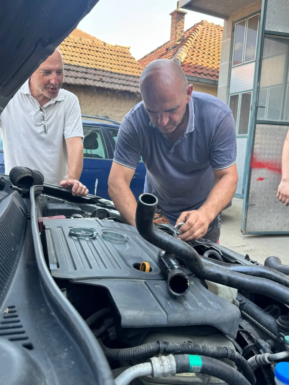 Majstor popravlja motor automobila pod otvorenom haubom