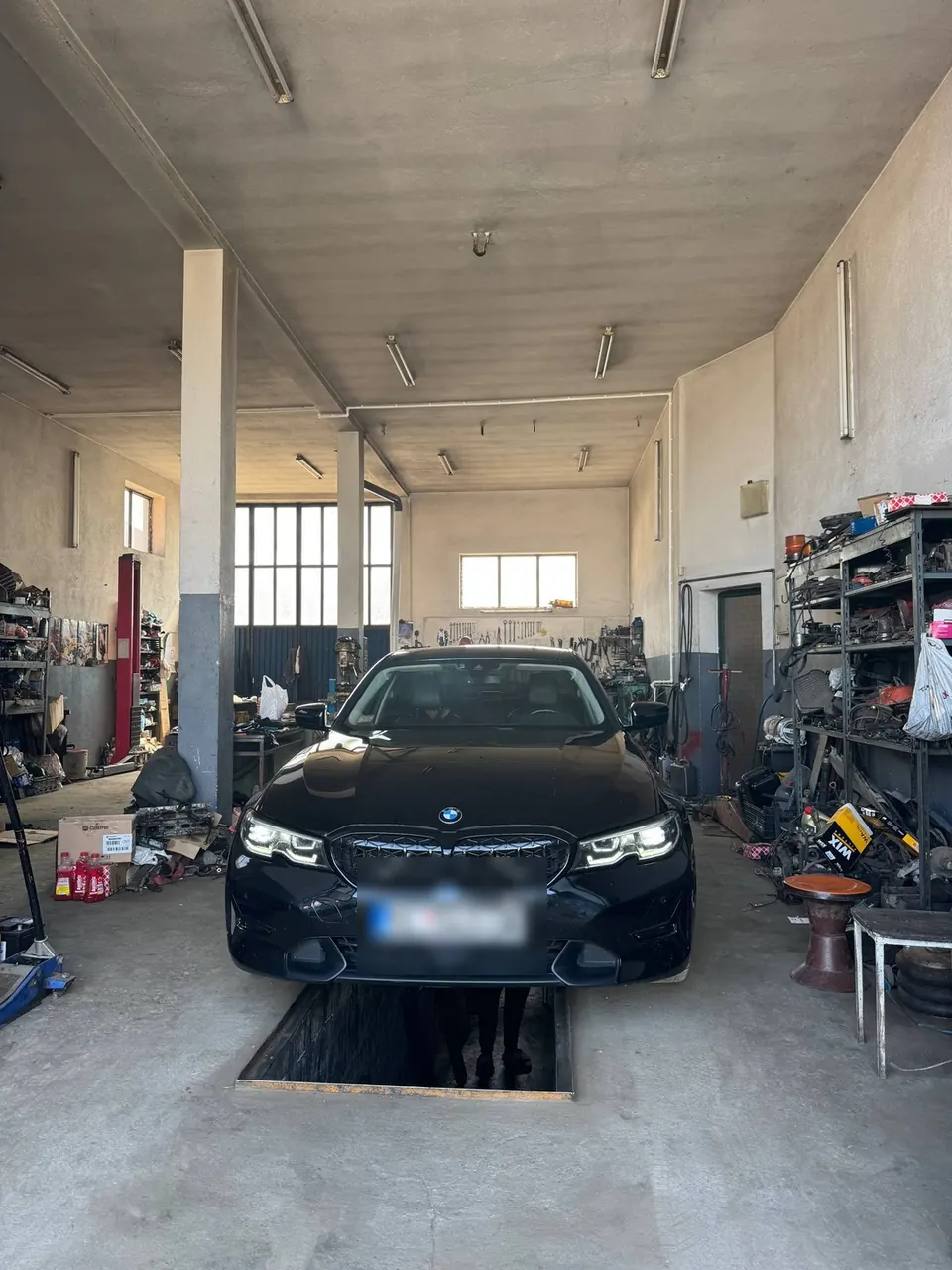 Crni BMW na kanalu za pregled u auto servisu