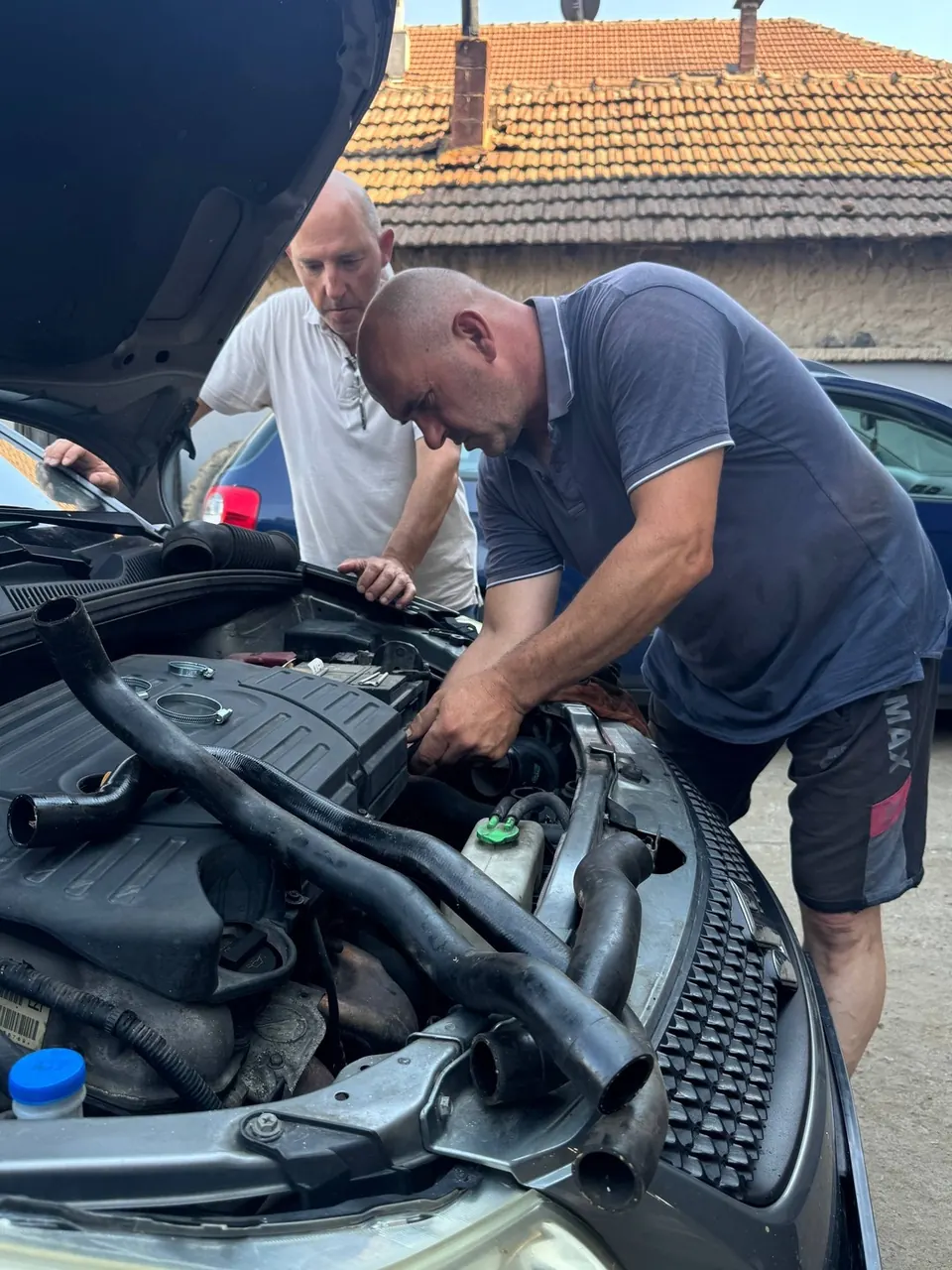Serviser proverava motor automobila u radionici